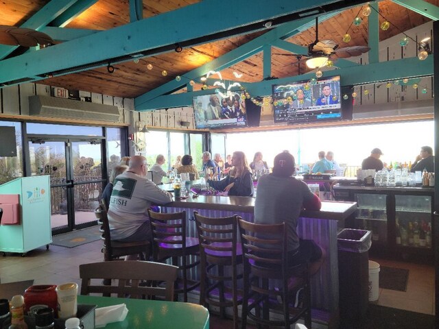 bar with tile patterned flooring, lofted ceiling with beams, ceiling fan, and wood ceiling