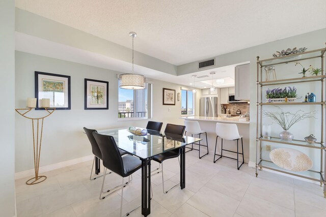 dining area with light tile patterned floors and a textured ceiling