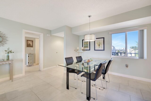 dining room featuring light tile patterned floors and a textured ceiling