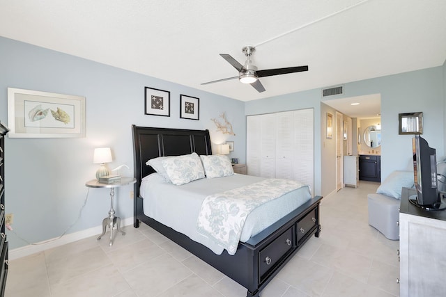 tiled bedroom featuring ceiling fan, ensuite bath, and a closet