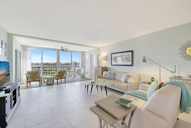 living room featuring light tile patterned floors, expansive windows, and ceiling fan