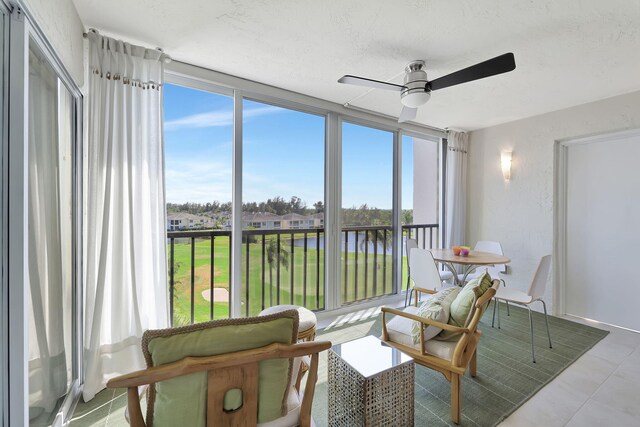 sunroom with a water view, plenty of natural light, and ceiling fan