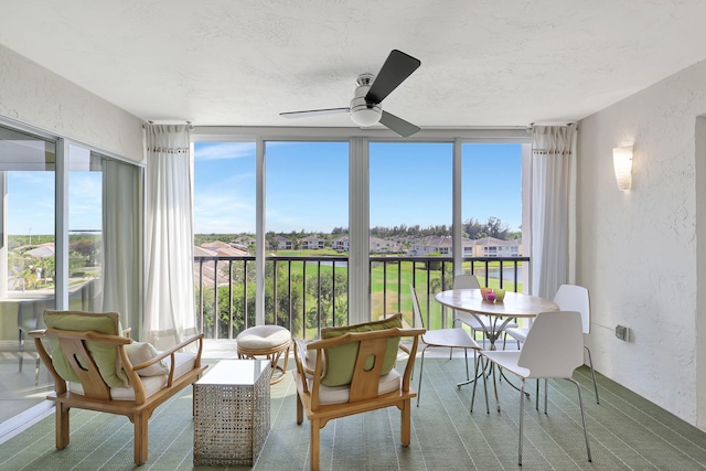 sunroom / solarium featuring ceiling fan