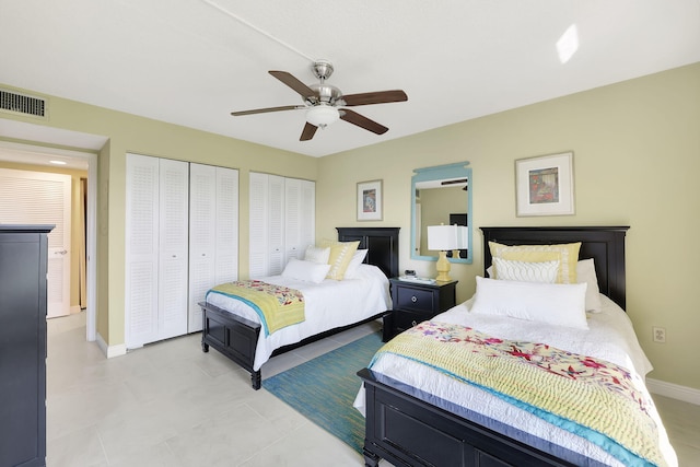 bedroom featuring visible vents, multiple closets, baseboards, and a ceiling fan