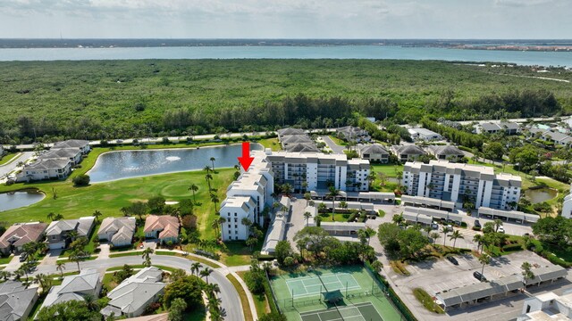 drone / aerial view featuring golf course view and a water view