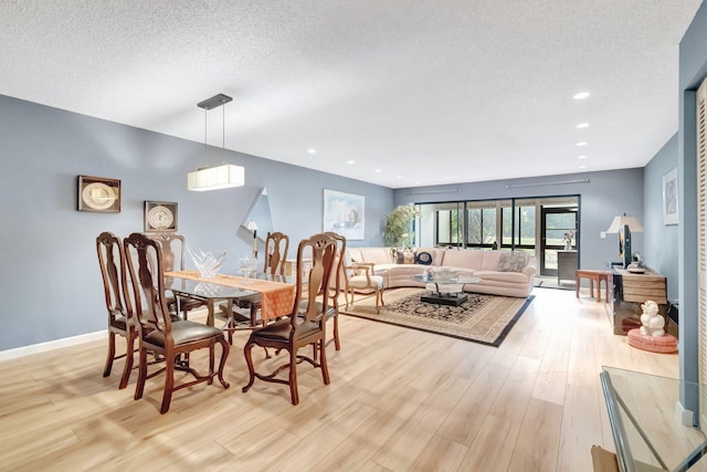 dining space featuring a textured ceiling and light hardwood / wood-style flooring