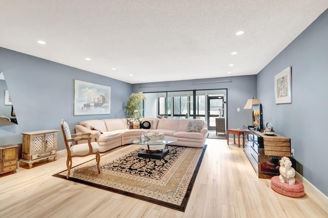 living room with light wood-type flooring and a textured ceiling