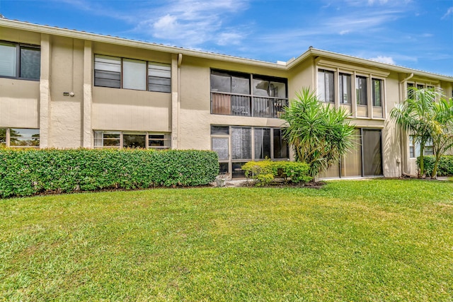 23 Westgate Ln Unit E, Boynton Beach, FL 33436 - back of house featuring a yard and stucco siding
