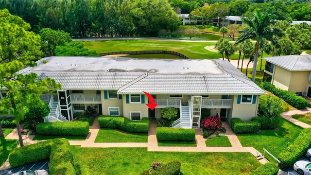 23 Westgate Ln Unit E, Boynton Beach, FL 33436 - rear view of house featuring a yard, a tile roof, stairway, and stucco siding
