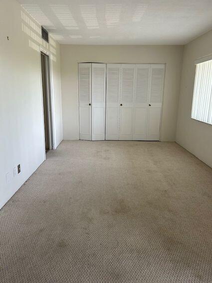 unfurnished bedroom with light colored carpet