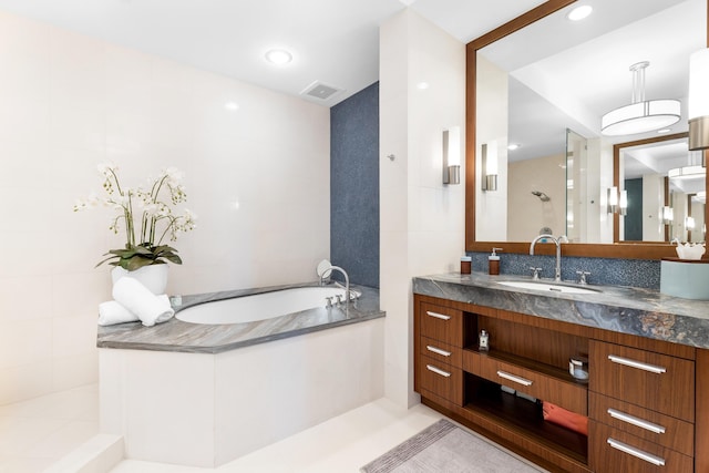 bathroom with independent shower and bath, tile floors, and vanity