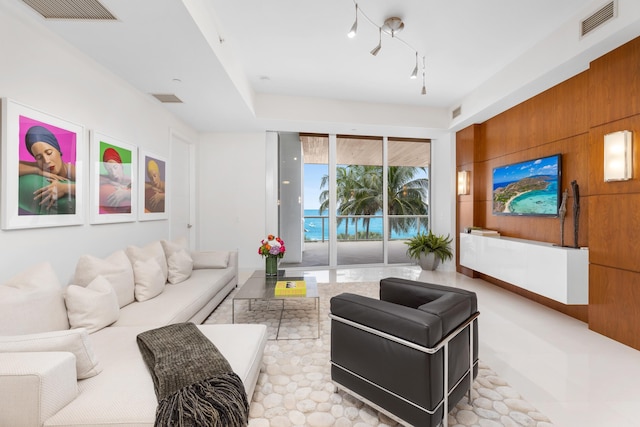 tiled living room featuring a water view and track lighting