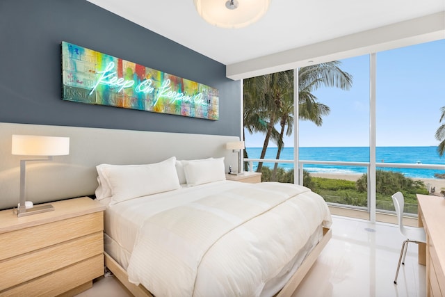 bedroom with a water view, tile floors, and multiple windows