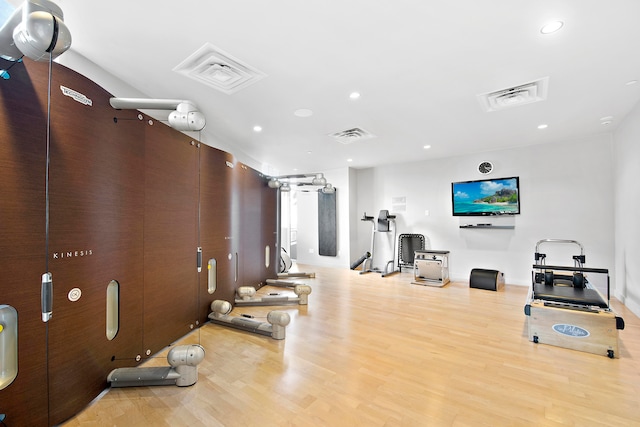 workout room with light hardwood / wood-style flooring