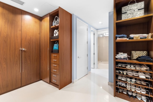 spacious closet with light tile floors