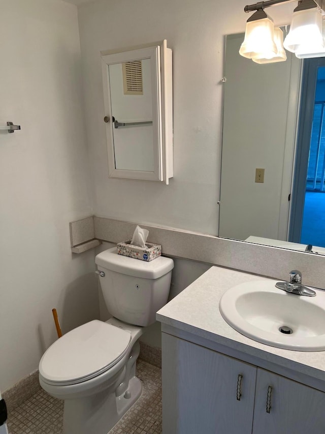 bathroom with toilet, tile floors, and vanity