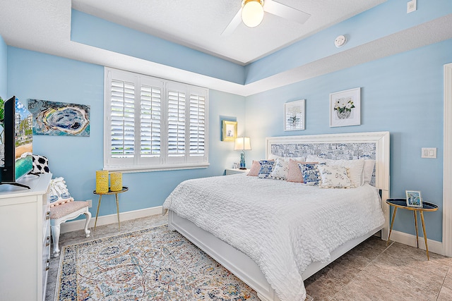 bedroom featuring ceiling fan, tile patterned floors, and a textured ceiling