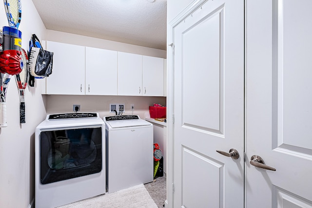 laundry room featuring cabinets, independent washer and dryer, and a textured ceiling