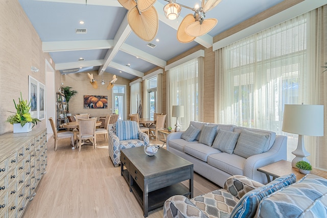 living room featuring an inviting chandelier, light hardwood / wood-style floors, and lofted ceiling with beams