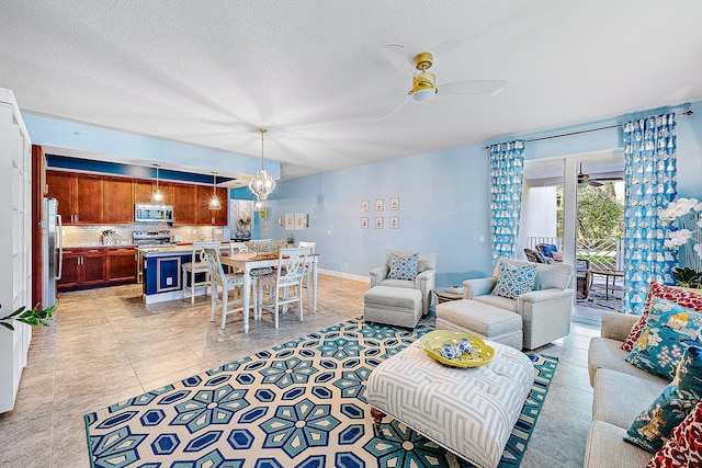 living room with a textured ceiling, ceiling fan, and light tile floors