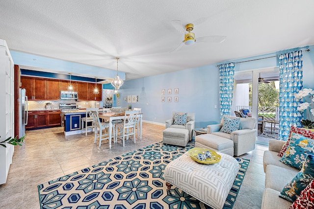 tiled living room with ceiling fan with notable chandelier and a textured ceiling