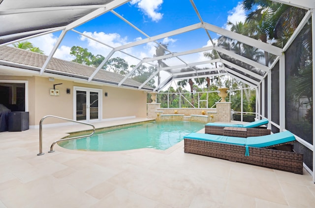 view of pool with french doors, a lanai, pool water feature, and a patio area