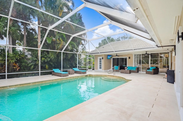 view of pool featuring a patio area, outdoor lounge area, ceiling fan, and a lanai