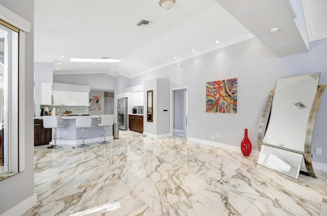 kitchen featuring backsplash, white cabinets, a breakfast bar, and light tile floors