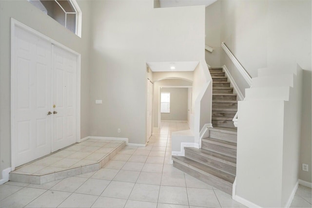 tiled entrance foyer with a towering ceiling