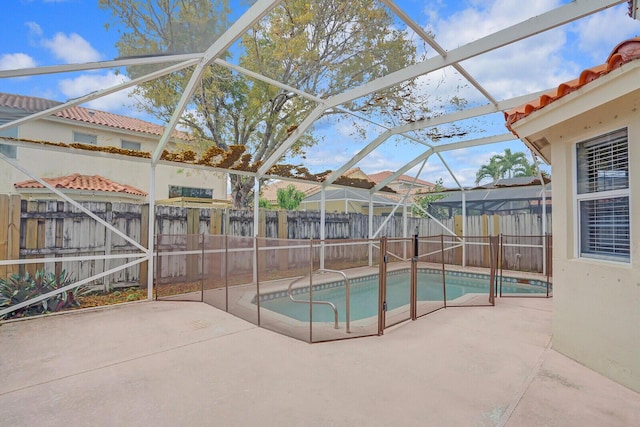 view of swimming pool featuring glass enclosure and a patio