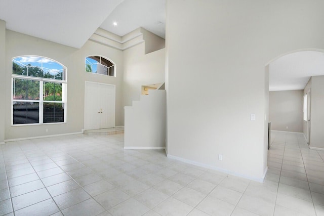 interior space featuring light tile patterned floors and a high ceiling