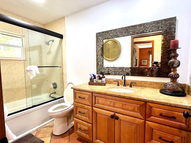 full bathroom with tile flooring, a textured ceiling, toilet, vanity, and shower / bath combination with glass door