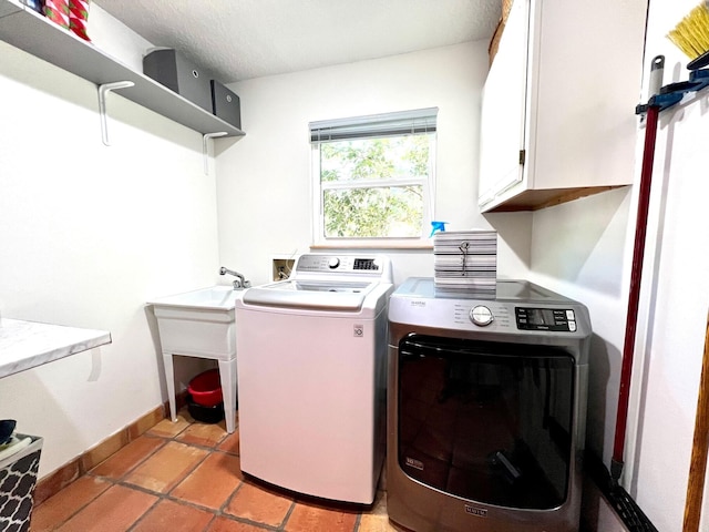 washroom with cabinets, independent washer and dryer, and light tile floors