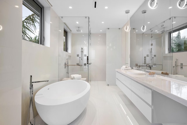 bathroom featuring plenty of natural light, separate shower and tub, tile floors, and vanity