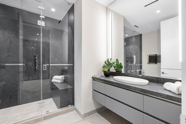 bathroom featuring a shower with door, tile floors, and large vanity