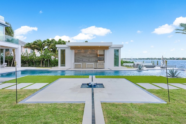 view of pool with a patio, exterior kitchen, and a lawn