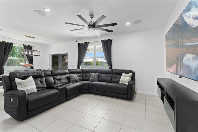 tiled living room with ceiling fan and a textured ceiling