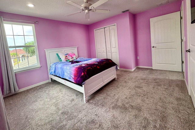 carpeted bedroom featuring a textured ceiling, a closet, and ceiling fan