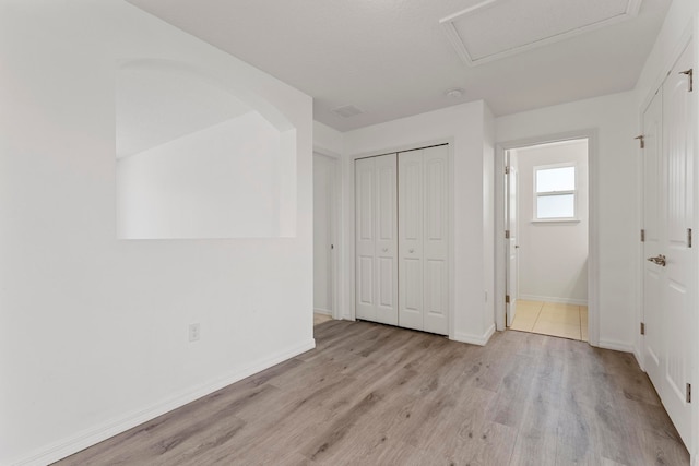 unfurnished bedroom with a closet and light hardwood / wood-style flooring