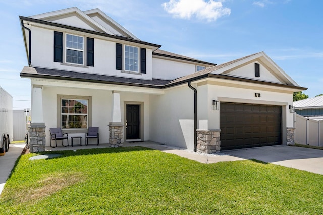 view of front of home featuring a garage, a front lawn, and covered porch