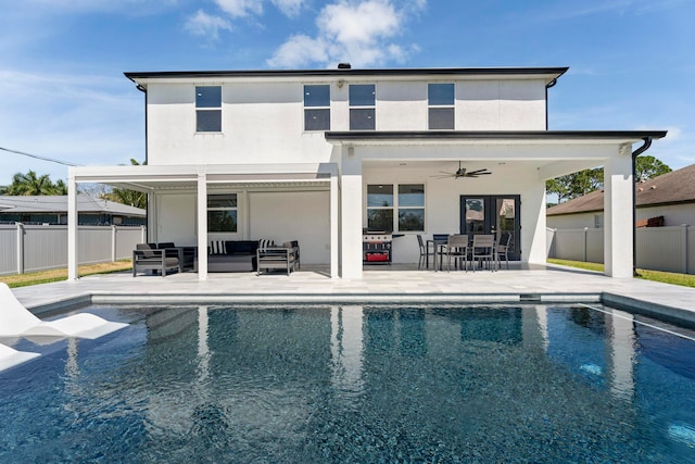 rear view of house featuring an outdoor living space, a patio area, a fenced in pool, and ceiling fan