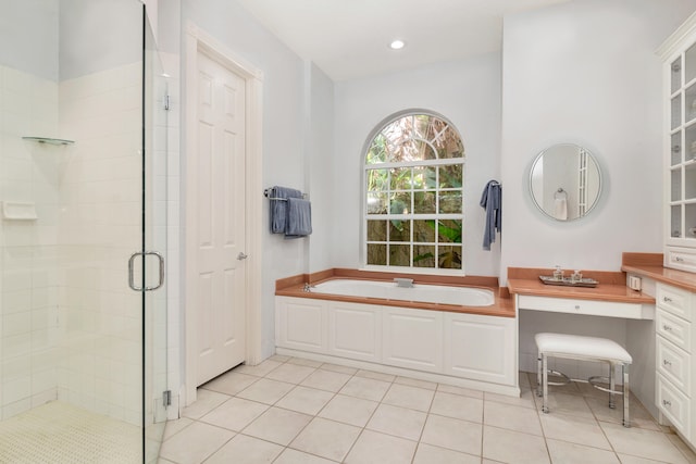 bathroom with independent shower and bath, vanity, and tile flooring