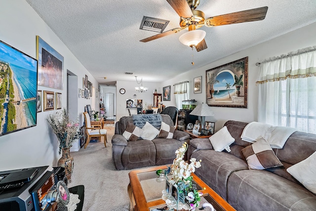 living room with ceiling fan with notable chandelier, light colored carpet, and a textured ceiling