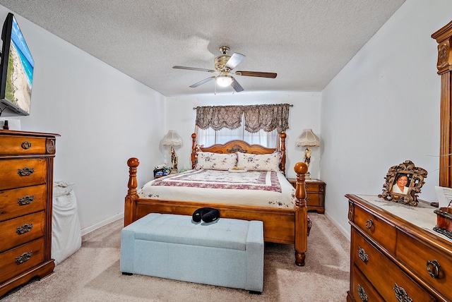 bedroom with light carpet, ceiling fan, and a textured ceiling