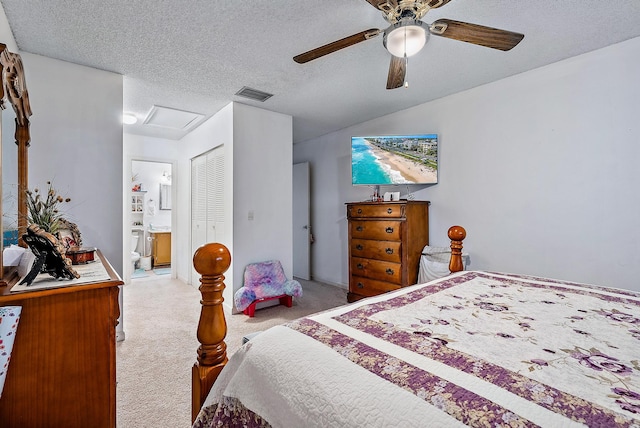 bedroom with light carpet, a closet, ensuite bathroom, ceiling fan, and a textured ceiling