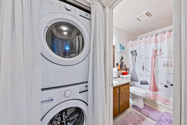 clothes washing area with stacked washer and dryer and tile flooring