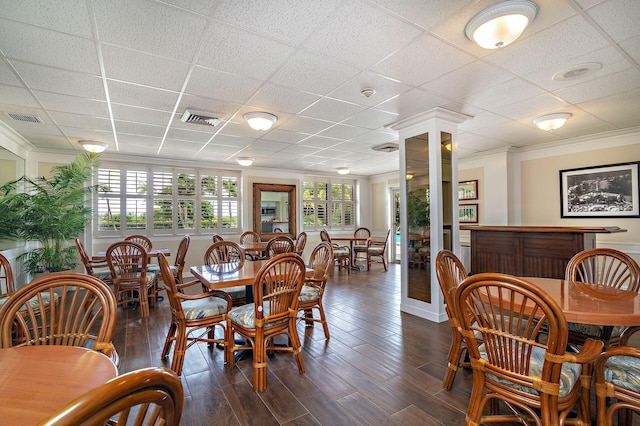 dining room with dark hardwood / wood-style floors, ornamental molding, and a paneled ceiling