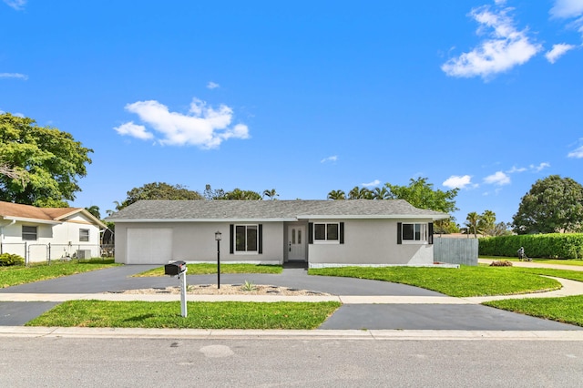 ranch-style house with a garage and a front yard