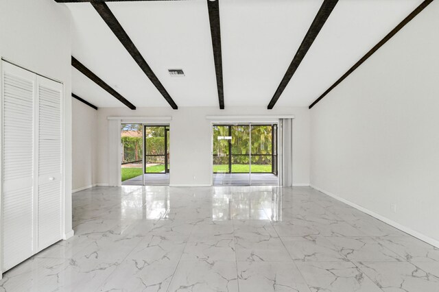 interior space featuring beamed ceiling and light tile floors