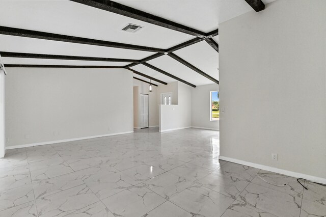 unfurnished living room with lofted ceiling with beams and light tile floors